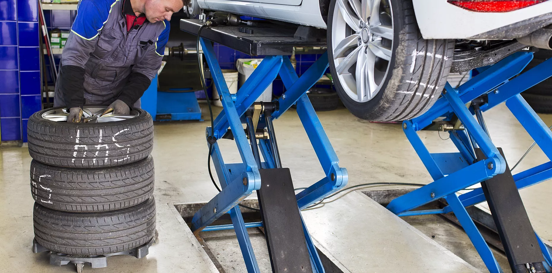 Automotive scissor lift using hydraulic cylinders in a vehicle service workshop